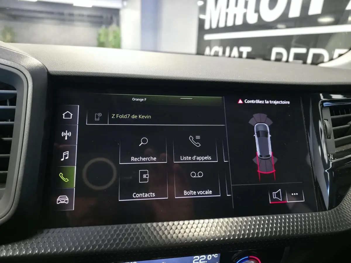 Affichage central tactile de l'Audi A1 Sportback 2024 montrant l'interface téléphone et l'aide au stationnement.