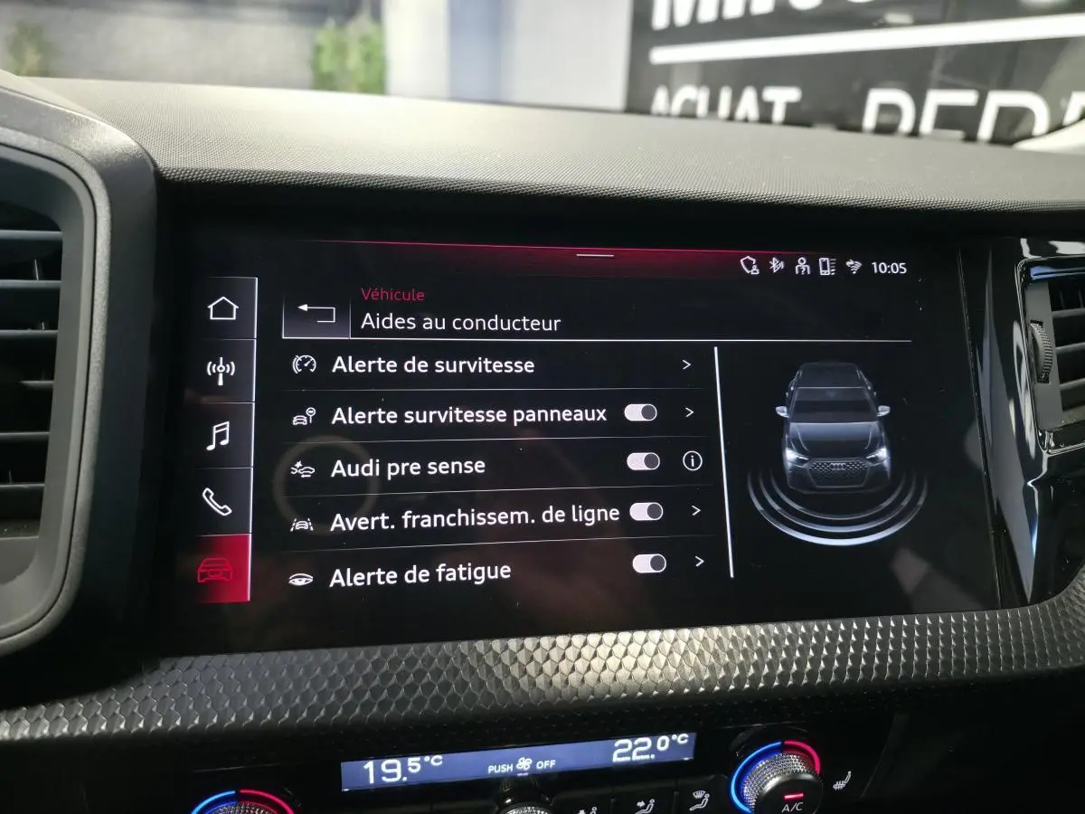 Écran tactile intérieur affichant les aides à la conduite de l'Audi A1 Sportback 2024 avec tableau de bord noir texturé.