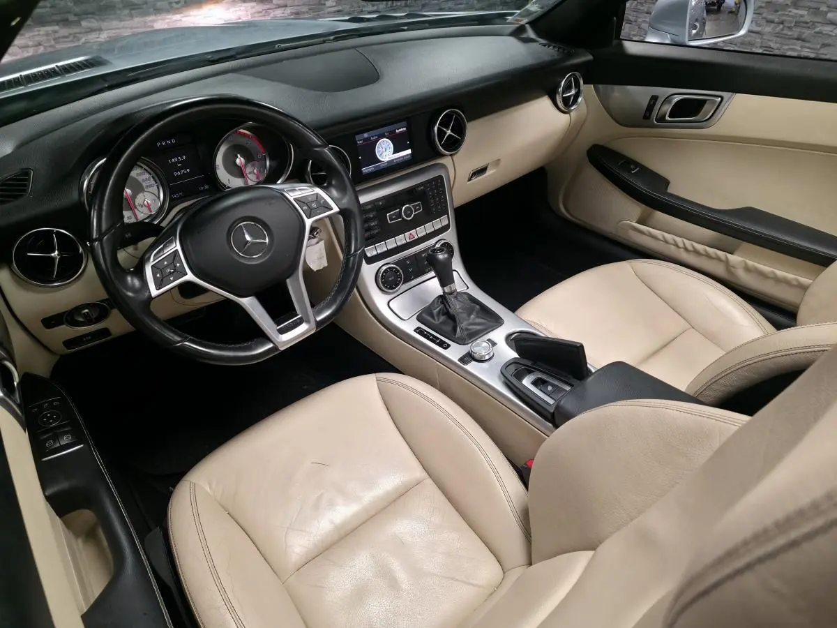 Intérieur beige cuir d'une Mercedes SLK 250 CDI 2012, vue côté conducteur avec tableau de bord et console centrale.