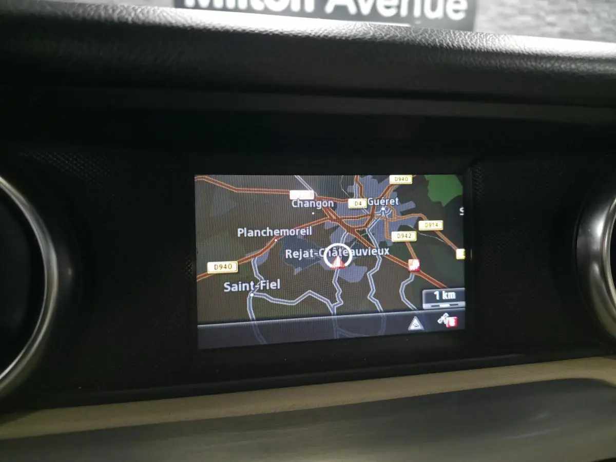 Écran de navigation Becker MAP PILOT affichant une carte 3D dans l'habitacle d'une Mercedes SLK gris 2012.