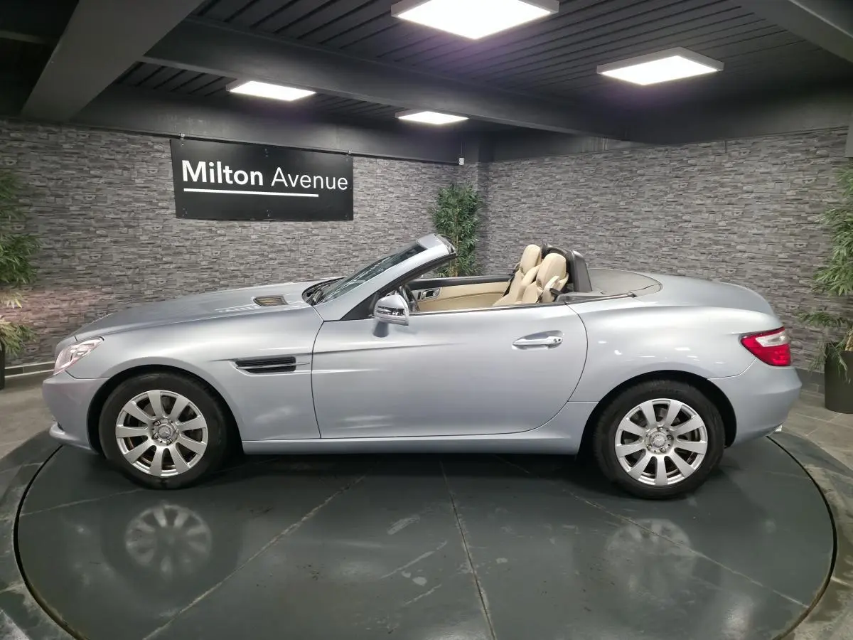 Mercedes SLK 250 CDI gris métallisé vue côté gauche, capote ouverte et sellerie cuir beige visible.