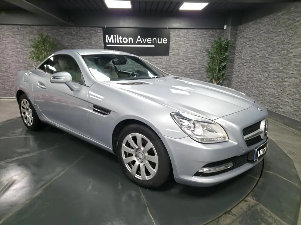 Mercedes SLK 250 CDI gris métallisé vue 3/4 avant droit avec jantes alliage et toit fermé dans un showroom.