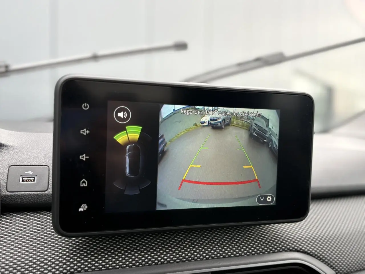 Écran tactile intérieur montrant la caméra de recul avec guidage coloré dans un Dacia Jogger Kaki Lichen.