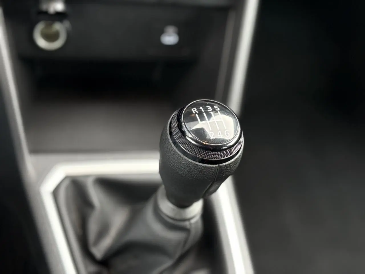Le levier de vitesses manuel en gros plan dans l'habitacle sombre du Dacia Jogger Kaki Lichen 2025.