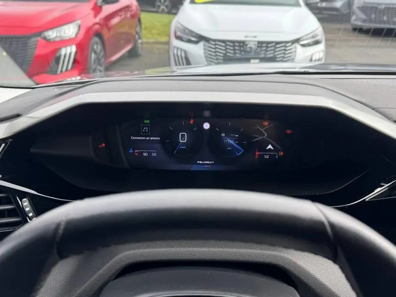 Vue intérieure du tableau de bord numérique de la Peugeot 308 2024, avec affichage central et volant partiellement visible.