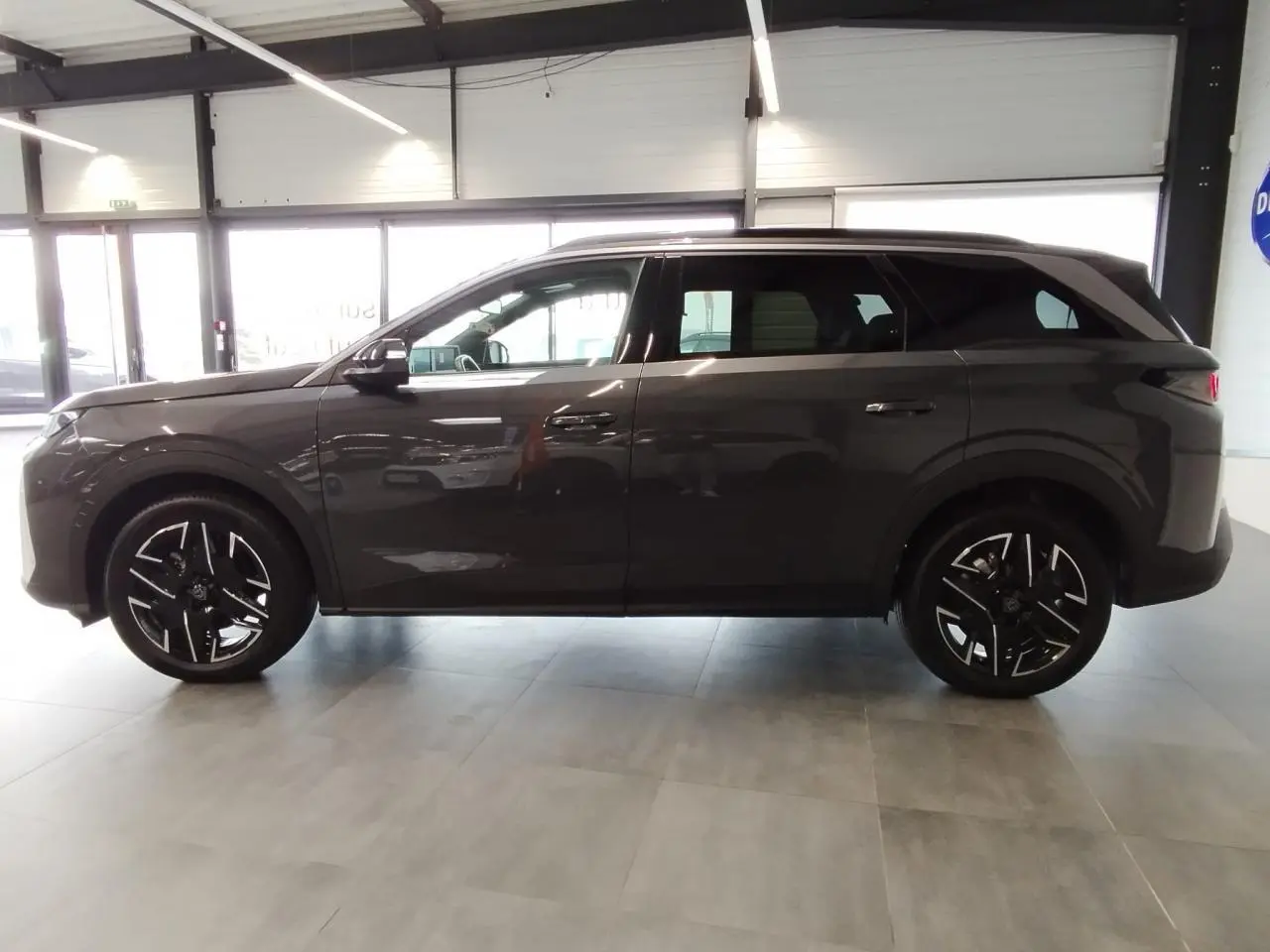 Peugeot 5008 gris titanium vue de profil côté gauche, jantes alliage noires diamantées et toit noir.