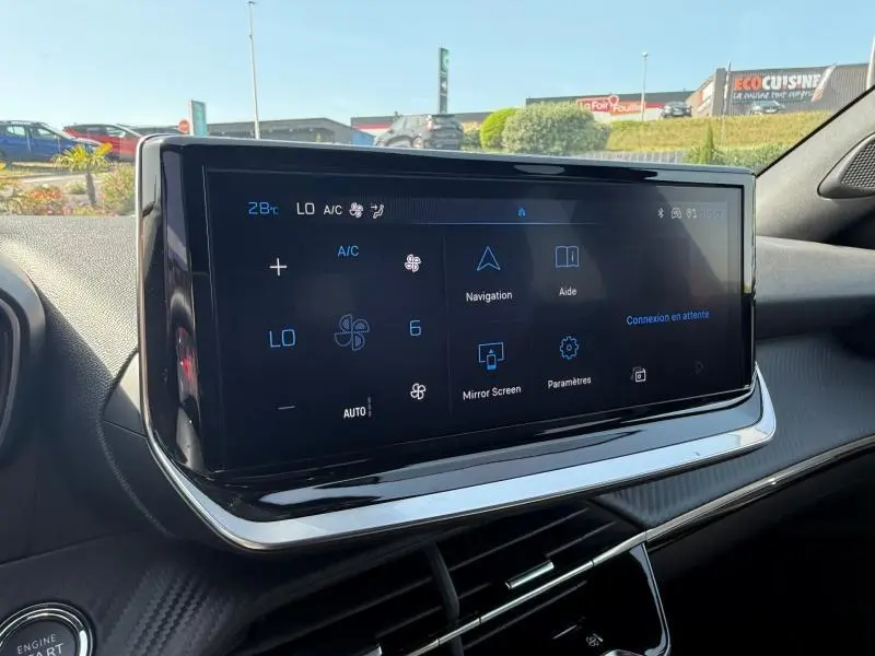 Écran tactile central du tableau de bord du Peugeot 2008, affichant les commandes de climatisation et navigation.