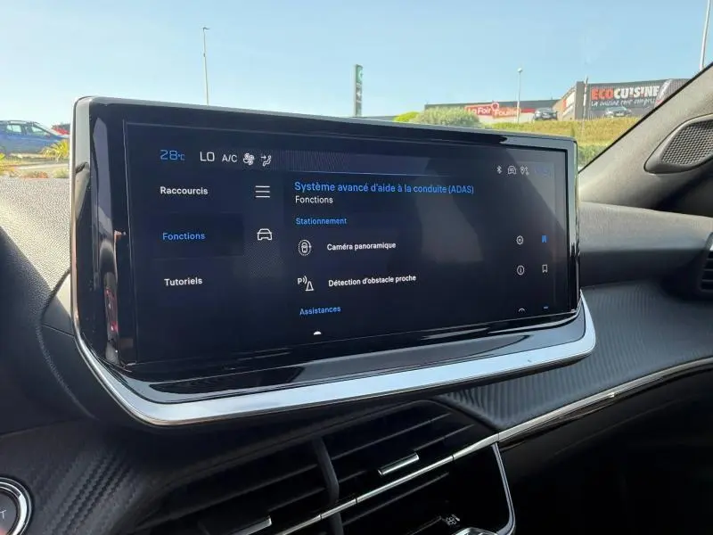 Écran tactile central du tableau de bord du Peugeot 2008 2025 affichant les aides à la conduite, intérieur noir moderne.