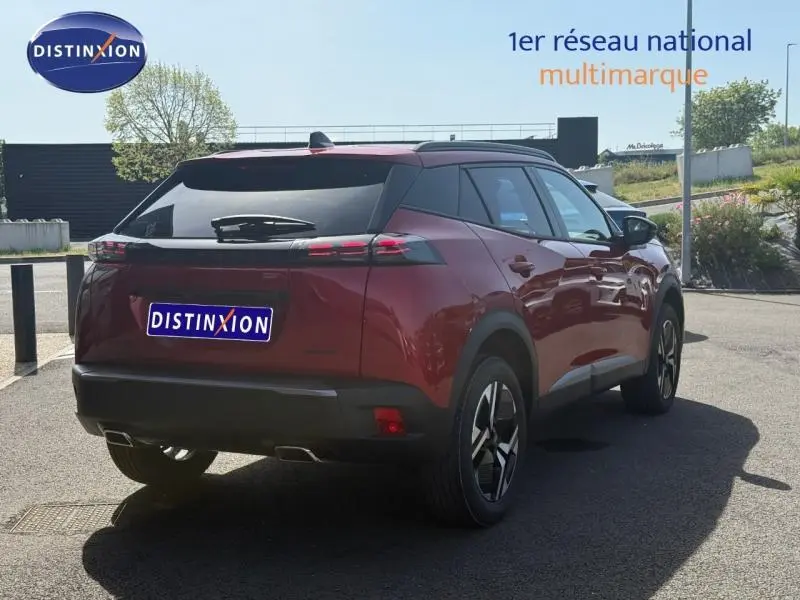 Vue 3/4 arrière droite d’un Peugeot 2008 rouge Elixir 2025 avec toit noir et jantes alliage distinctives.