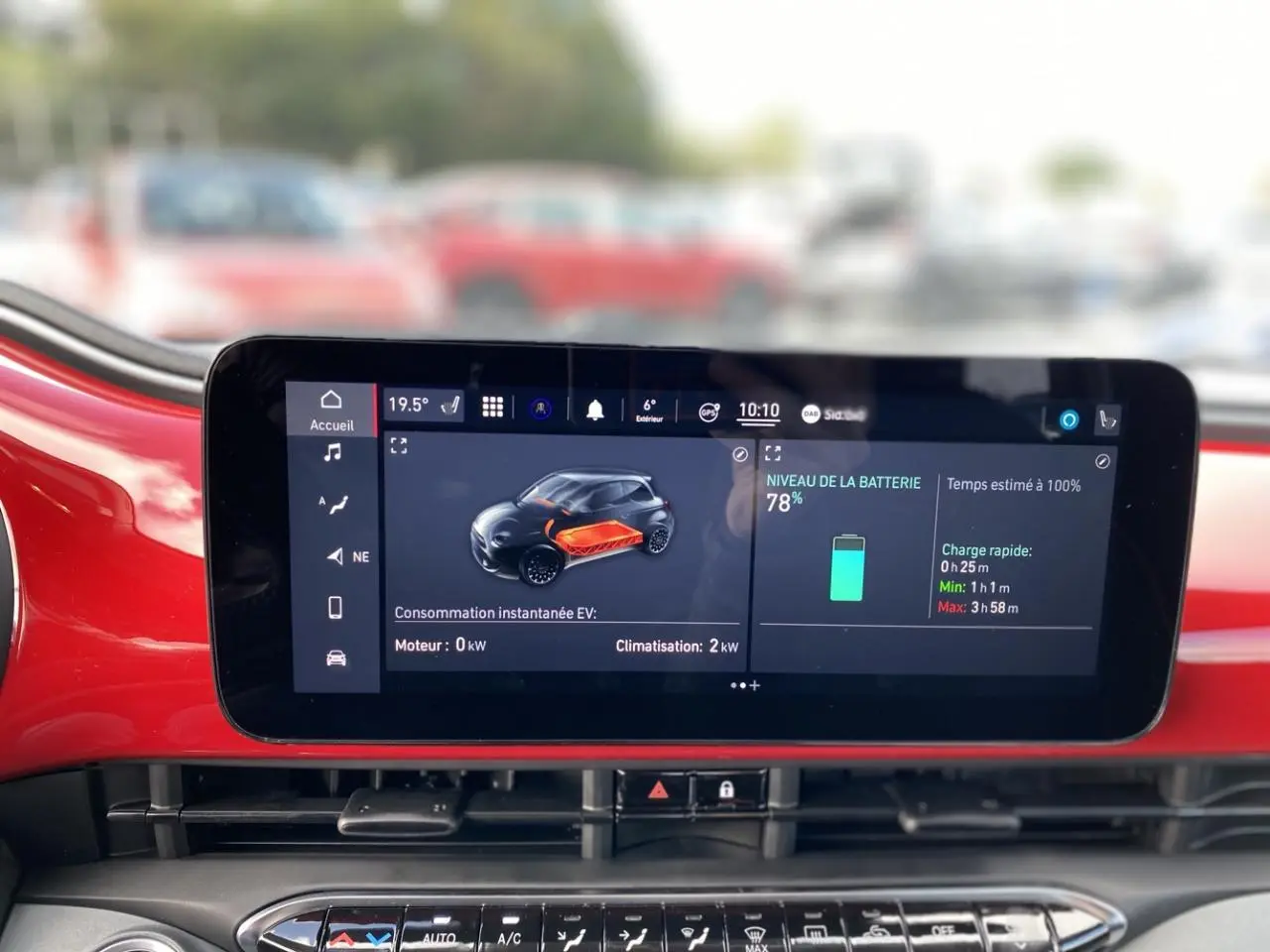 Écran tactile central affichant l'état de batterie et consommation sur fond intérieur rouge vif d'une Fiat 500 Cabriolet Electrique.