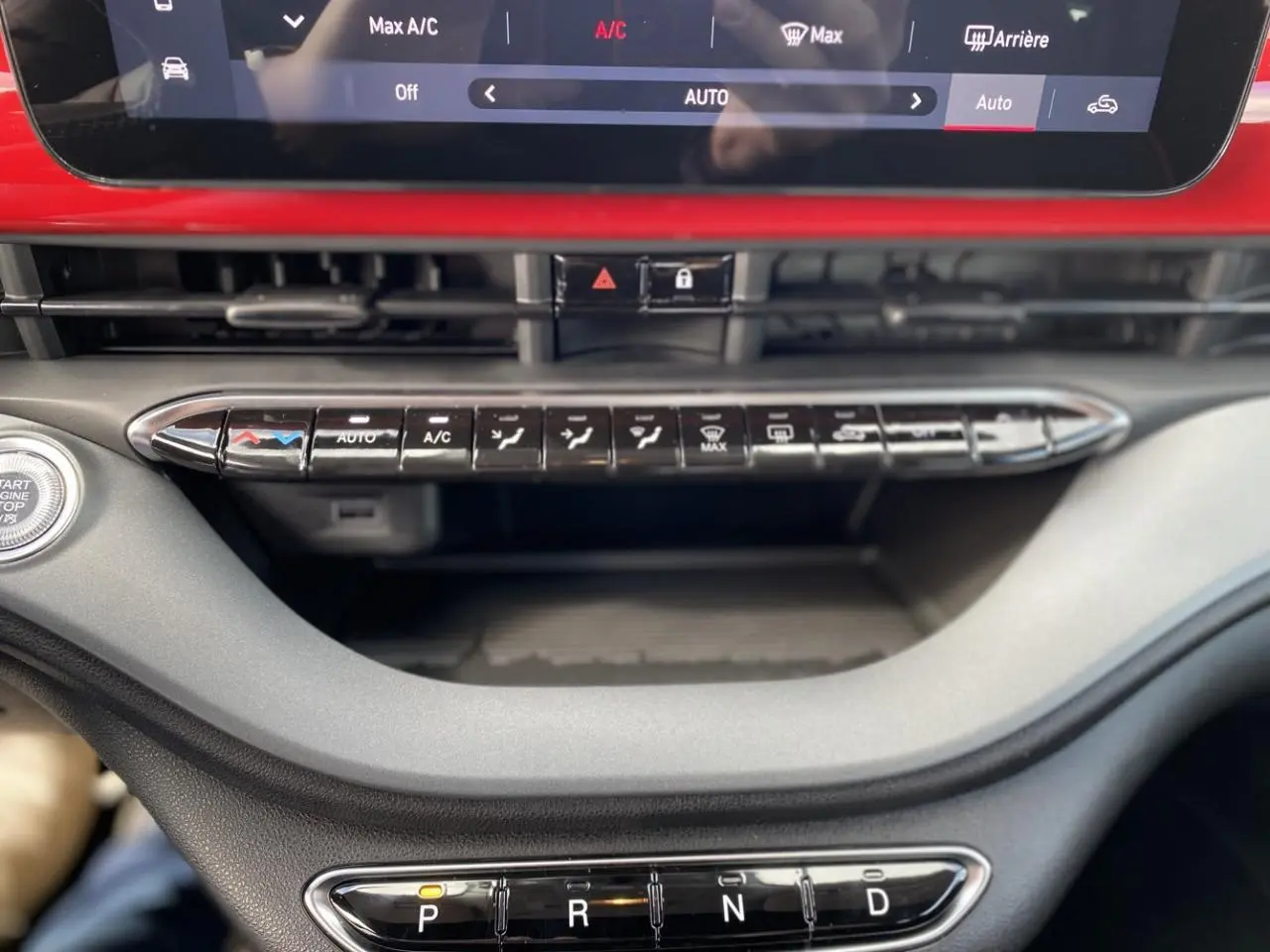Vue rapprochée de la console centrale rouge d'une Fiat 500 Cabriolet électrique 2022 avec commandes climatisation et boîte auto.