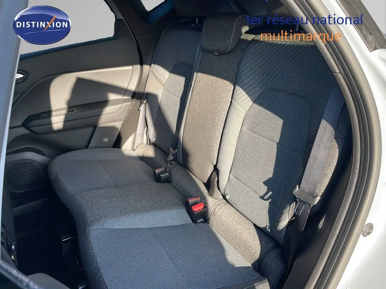 Vue intérieure sur la banquette arrière en tissu gris du Renault Captur E-Tech 2025 avec porte ouverte côté droit.