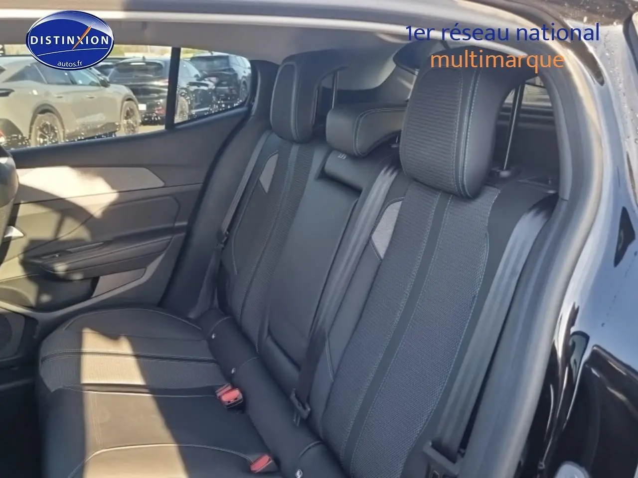 Vue intérieure côté gauche sur la banquette arrière noire en tissu et cuir du Peugeot 408 Hybrid 145 allure e-dcs6 2025.