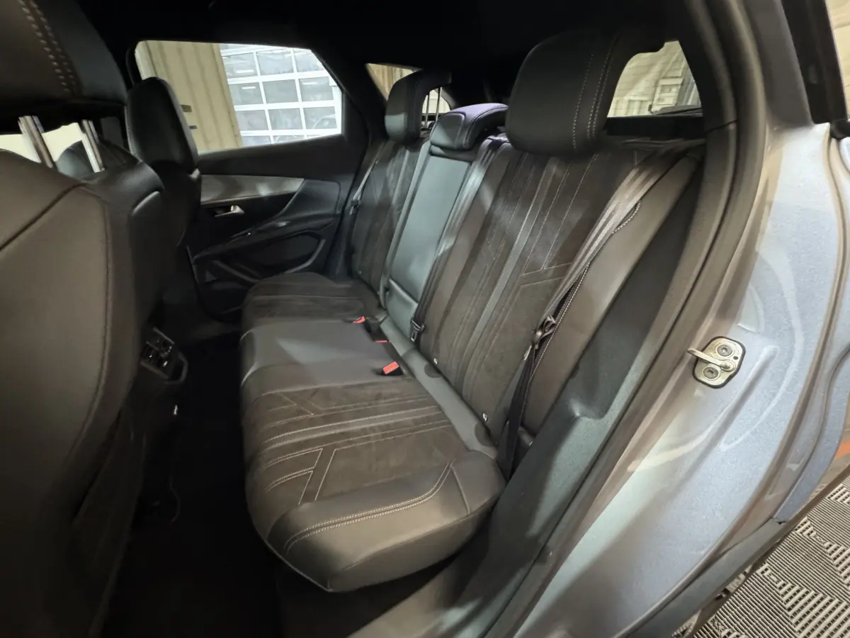 Vue intérieure côté droit montrant la banquette arrière en cuir noir du Peugeot 3008 gris clair 2021.