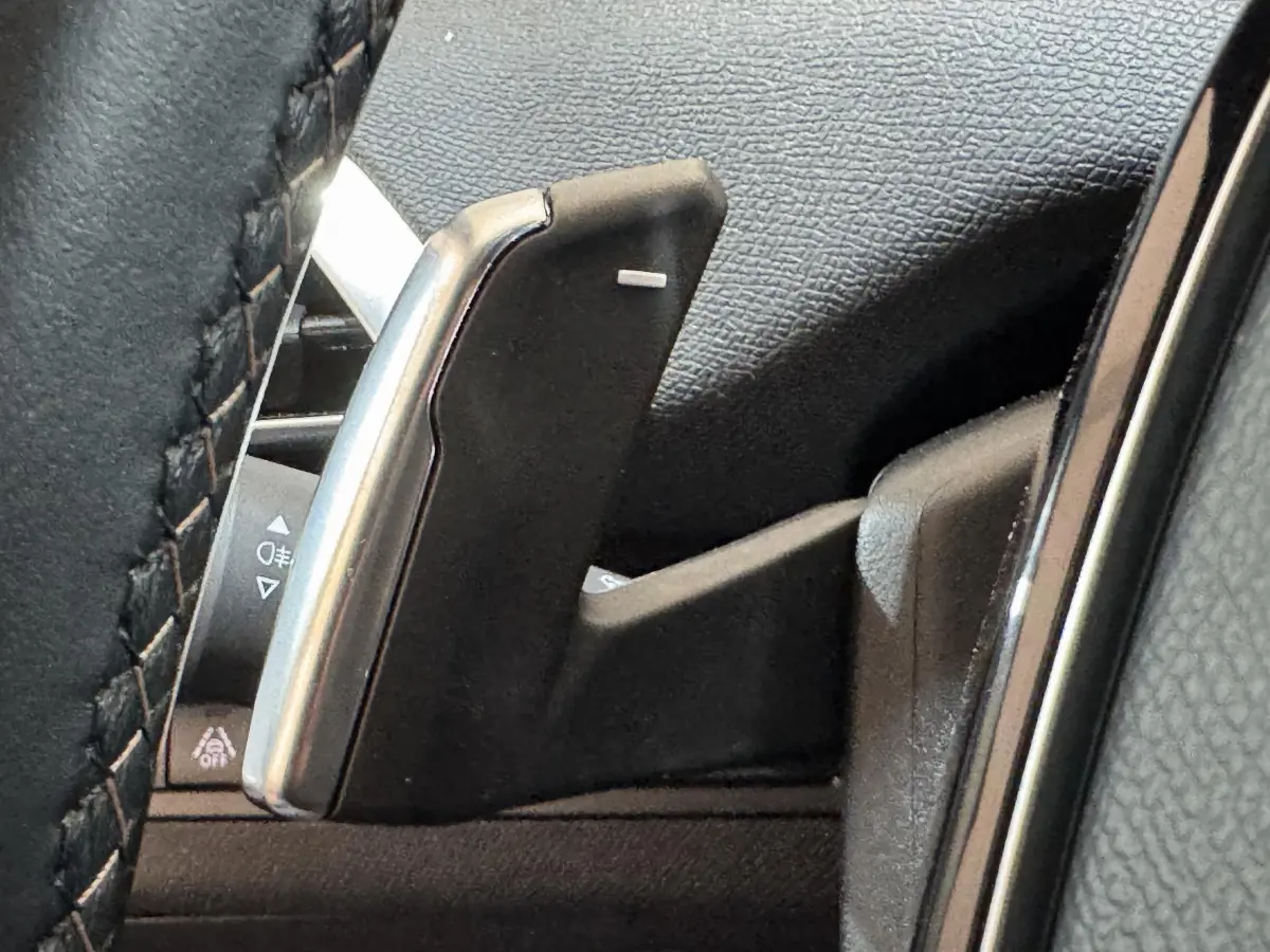 Gros plan sur la palette de changement de vitesse en aluminium côté droit du volant cuir noir du Peugeot 3008 gris clair.
