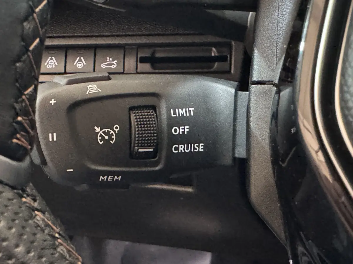 Gros plan sur la commande de régulateur de vitesse du Peugeot 3008 GT 2021, avec boutons noirs et marquages blancs.