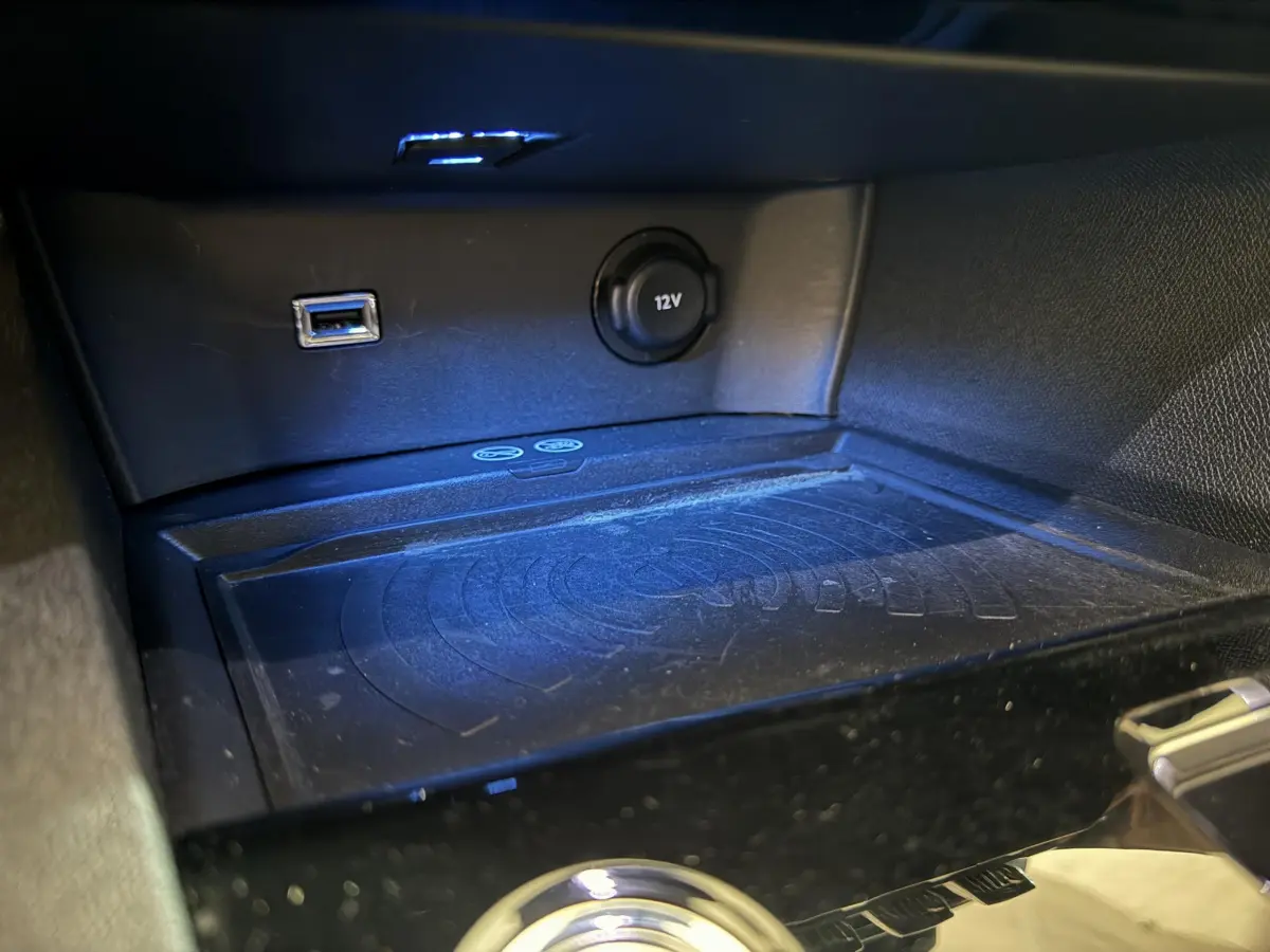 Gros plan sur la console centrale du Peugeot 3008 GT 2021, montrant prise USB, prise 12V et zone de recharge sans fil.
