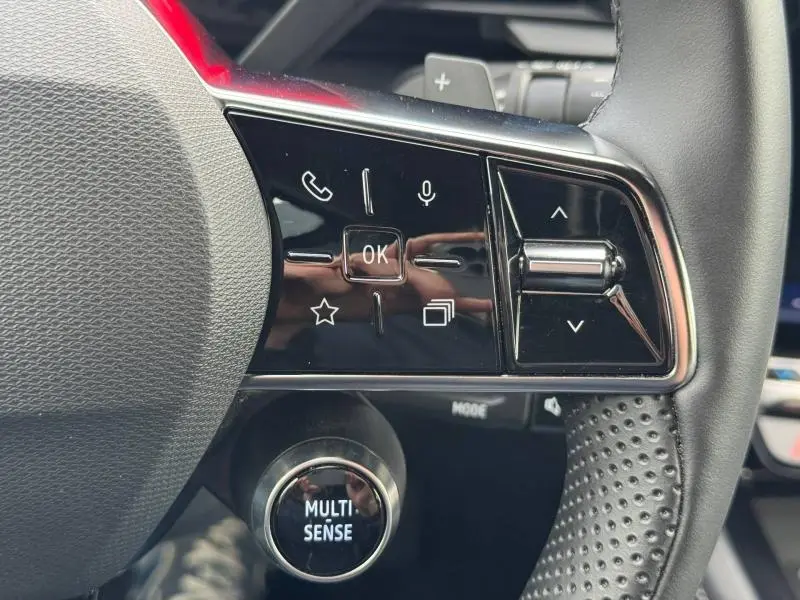 Gros plan sur les commandes au volant côté droit du Renault Austral 2025 avec bouton Multi-Sense et finition noire brillante.