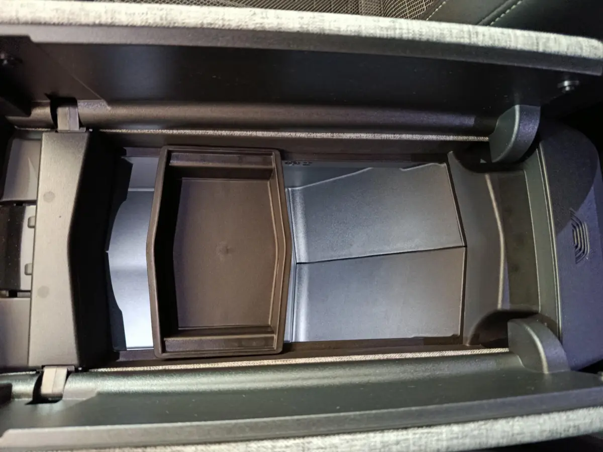 Vue plongeante sur le rangement central intérieur du Peugeot 3008 1.2 Hybrid 145 GT, avec compartiment noir et finition grise.