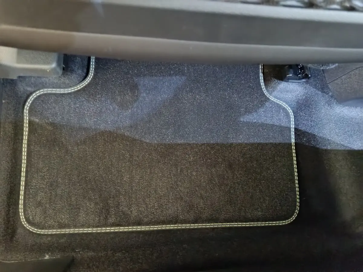 Tapis de sol noir avec surpiqûres blanches, vue rapprochée de l'intérieur côté conducteur du Peugeot 3008 2025.
