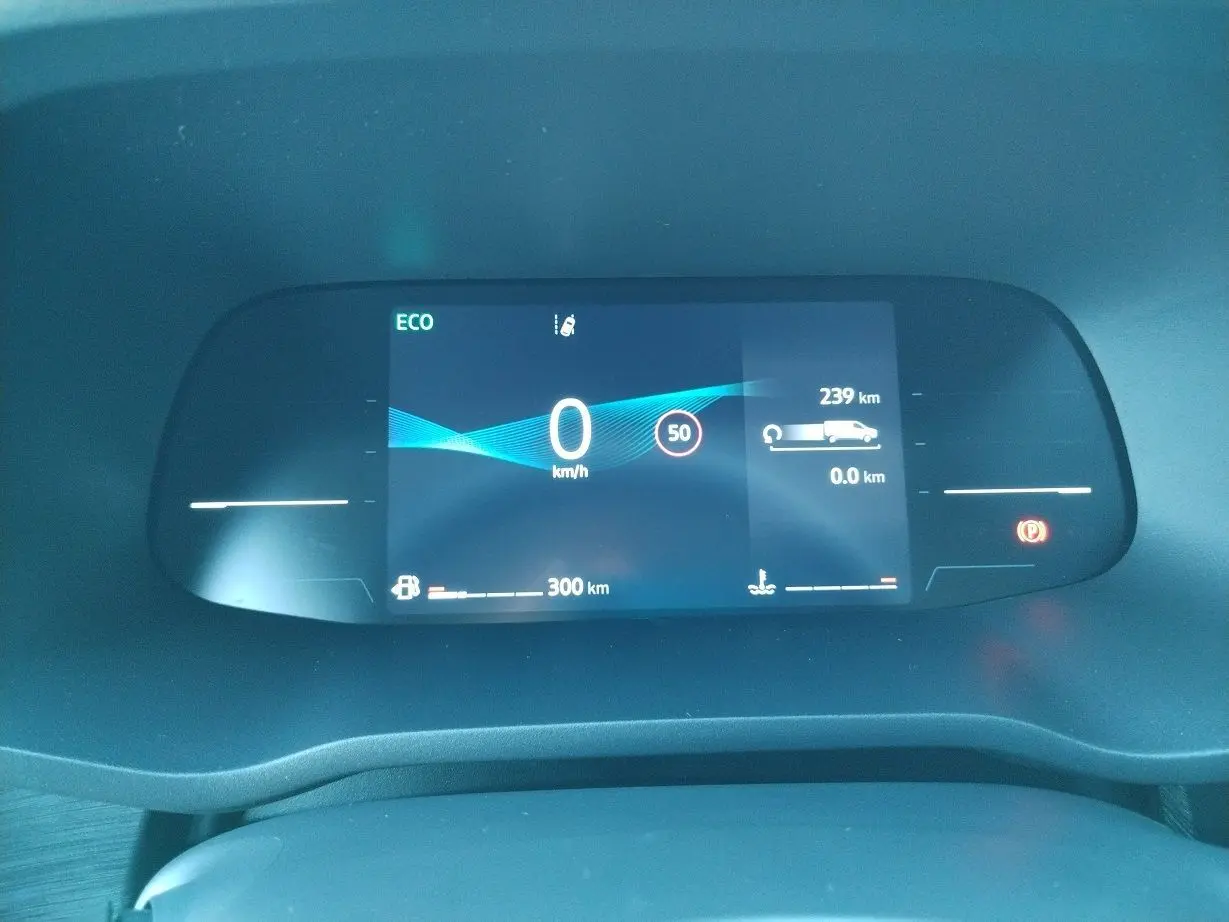 Tableau de bord numérique du Nissan Primastar blanc 2025 affichant vitesse zéro et autonomie restante.