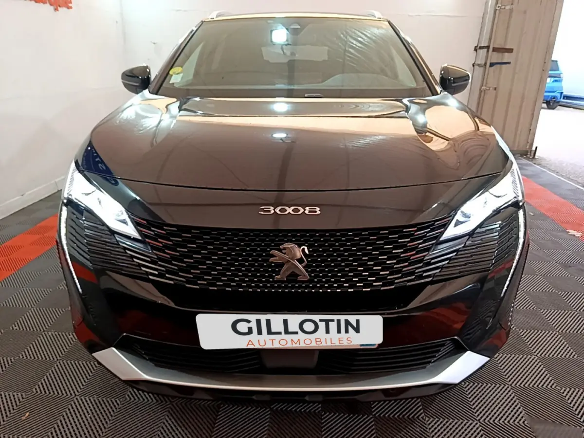 Vue avant frontale du Peugeot 3008 noir 2023 avec calandre distinctive et phares LED allumés.