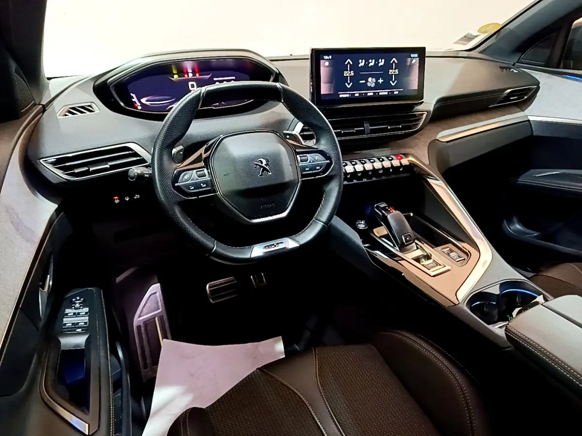 Vue intérieure avant du Peugeot 3008 GT 2023, volant cuir, écran tactile central et console moderne noire.