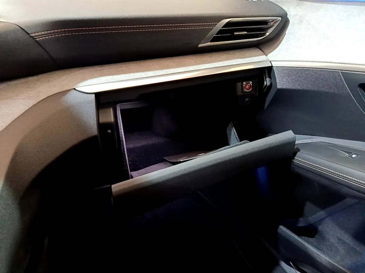 Intérieur Peugeot 3008 GT 2023, vue sur la boîte à gants ouverte côté passager avec surpiqûres orange visibles.