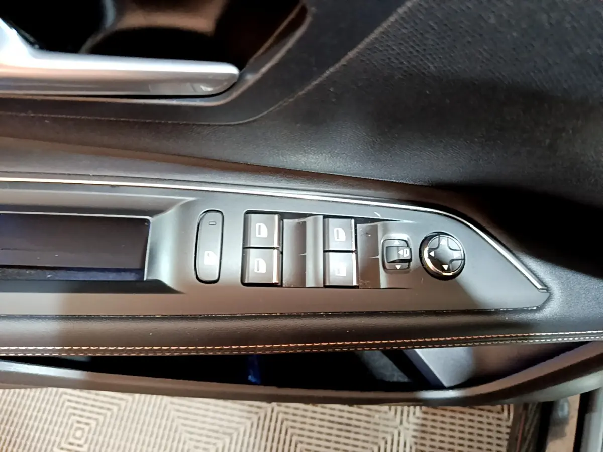 Vue rapprochée des commandes de lève-vitres et rétroviseurs sur la porte côté gauche du Peugeot 3008 noir 2023.
