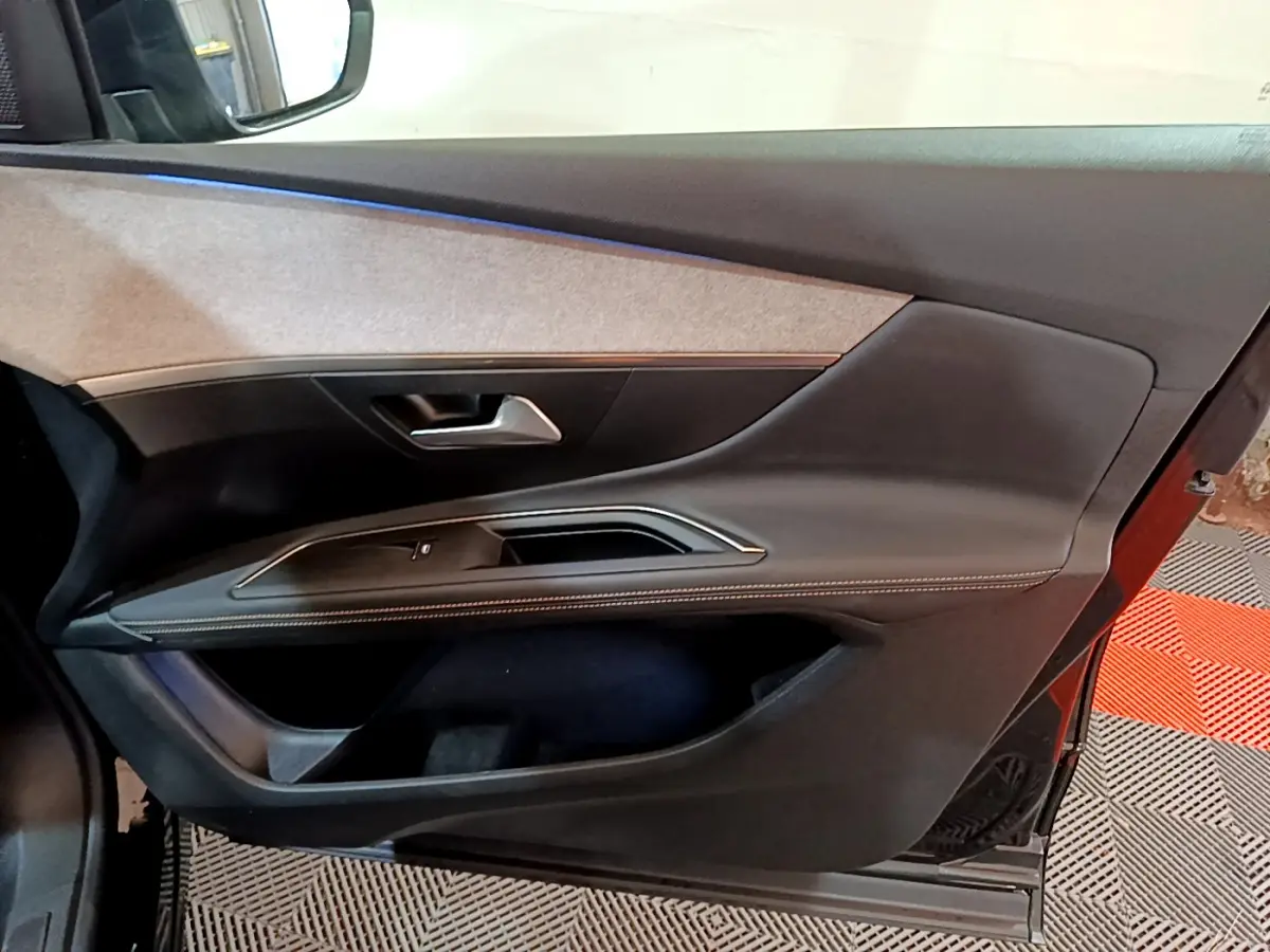 Vue intérieure de la porte avant gauche du Peugeot 3008 noir, avec garniture tissu et détails en surpiqûres contrastées.