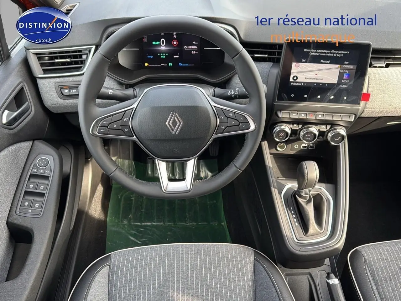 Vue intérieure avant de la Renault Clio V 1.6 e-tech avec tableau de bord numérique et console centrale moderne.