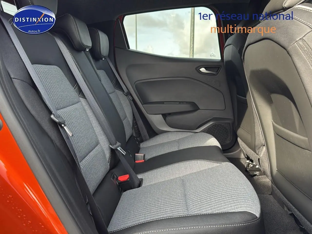 Vue latérale gauche de la banquette arrière grise et noire dans une Renault Clio V orange Valencia 2025.
