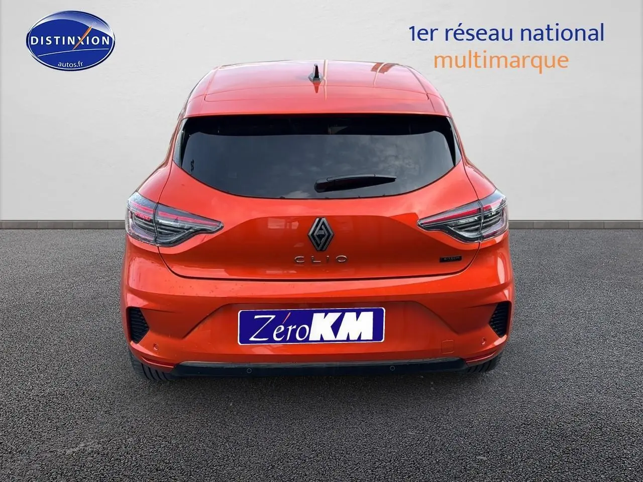 Vue arrière d'une Renault Clio V orange Valencia avec feux LED et logo central sur fond neutre.