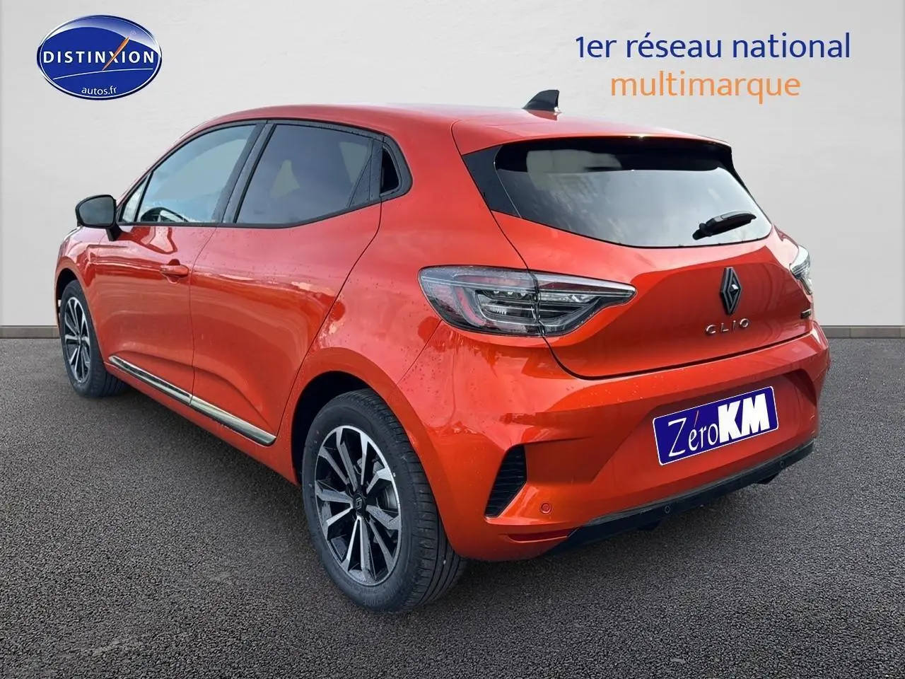 Vue 3/4 arrière droite d'une Renault Clio V orange Valencia avec jantes alliage et becquet arrière.