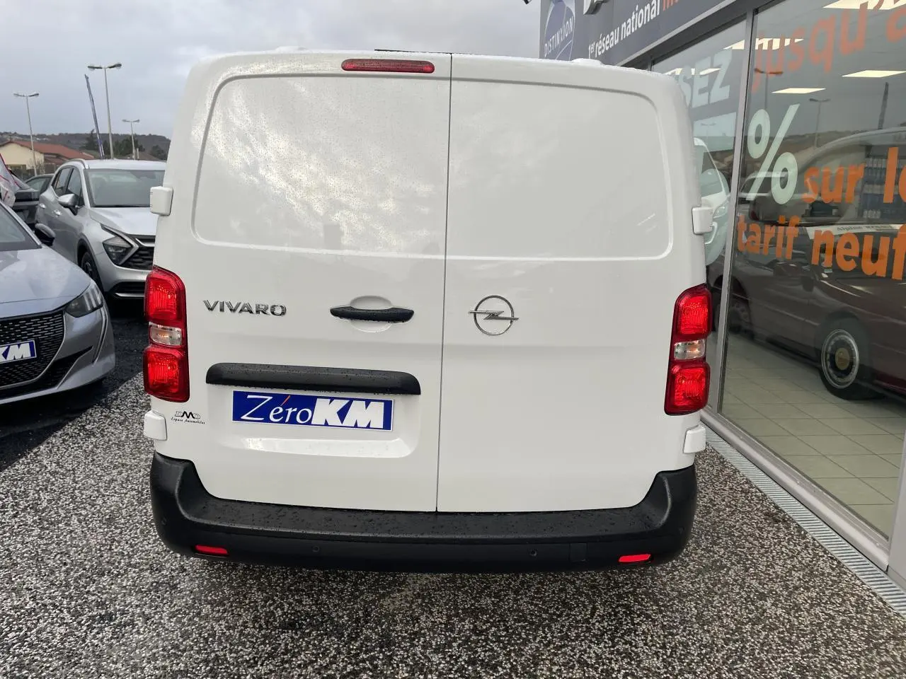 Vue arrière d'un utilitaire Opel Vivaro blanc 2024 avec portes battantes et pare-chocs noirs.