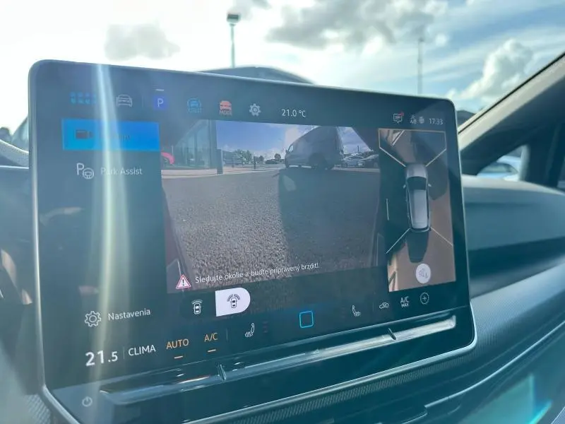 Écran tactile intérieur de la Volkswagen Golf 2025 gris, affichant l'assistance au stationnement avec vue caméra 360°