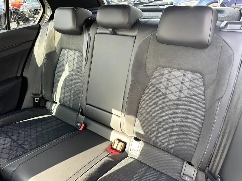 Vue intérieure arrière des sièges en tissu gris et alcantara de la Volkswagen Golf 1.5 eTSI R-Line Edition 2025.