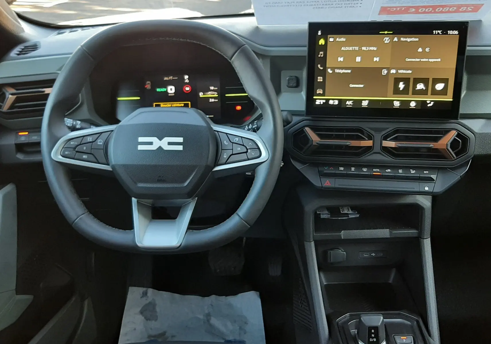 Vue intérieure du tableau de bord du Dacia Duster 2025 avec volant multifonction et écran tactile central.
