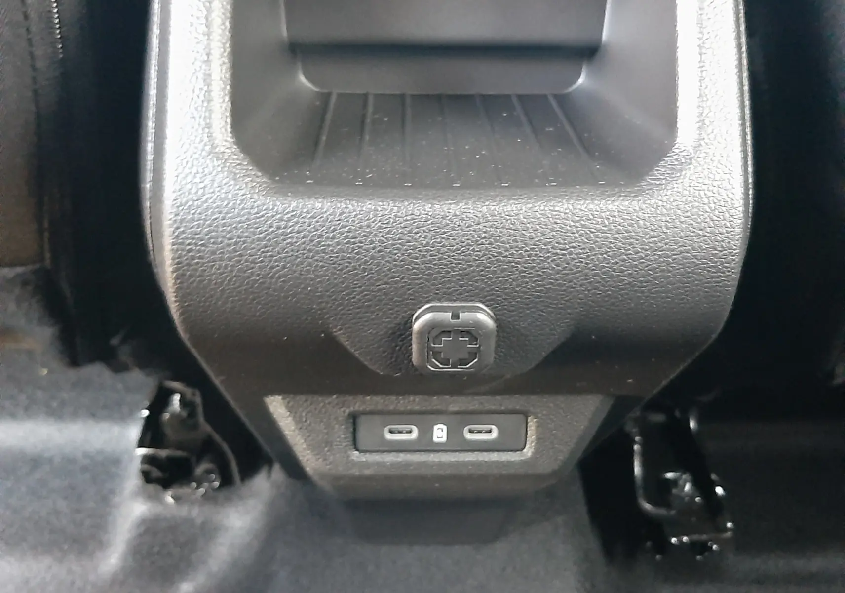 Prise USB arrière double et rangement en plastique noir dans l'habitacle du Dacia Duster 2025 couleur Sandstone.