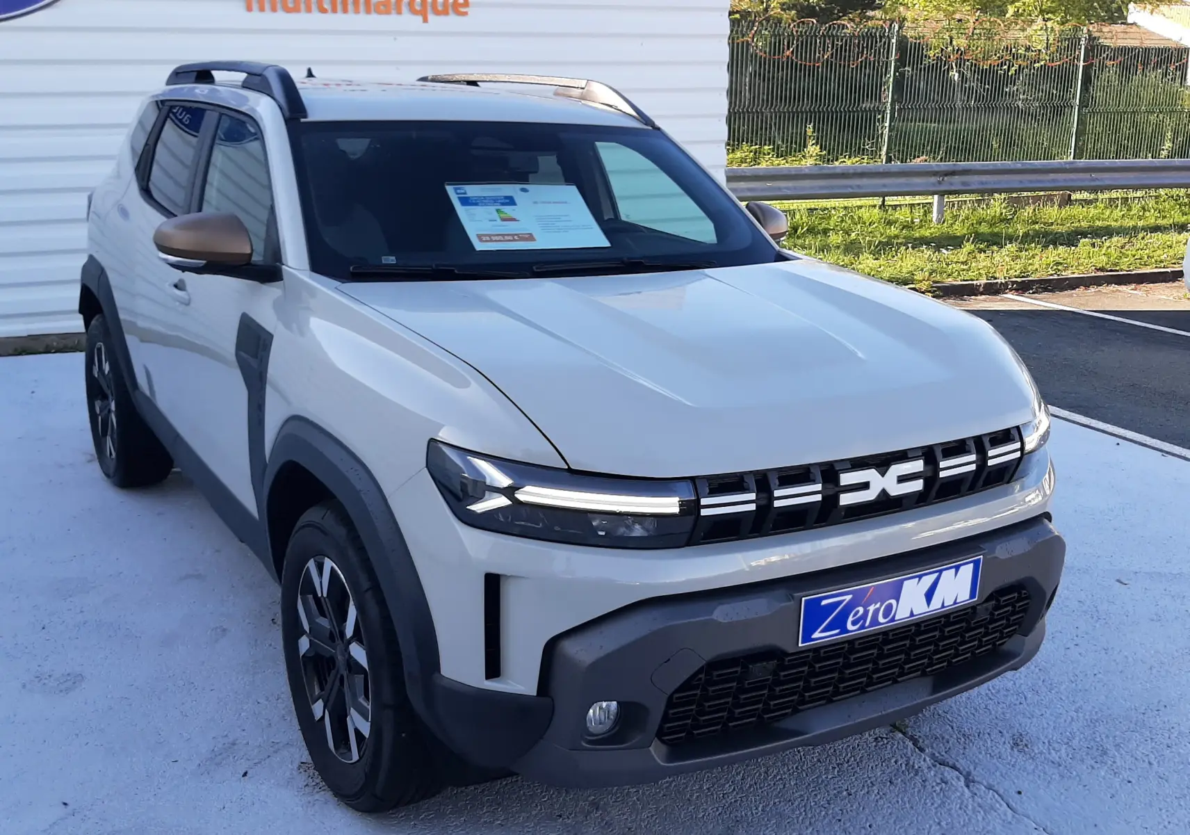 Dacia Duster 1.6 Hybrid 140ch Extreme couleur Sandstone en 3/4 avant droit avec calandre noire et jantes biton.