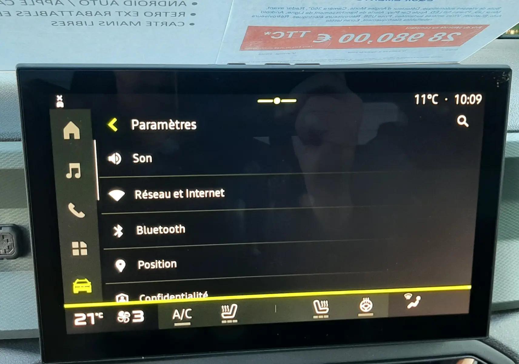 Vue intérieure du tableau de bord du Dacia Duster 2025 avec écran tactile affichant les paramètres, ambiance moderne et fonctionnelle.