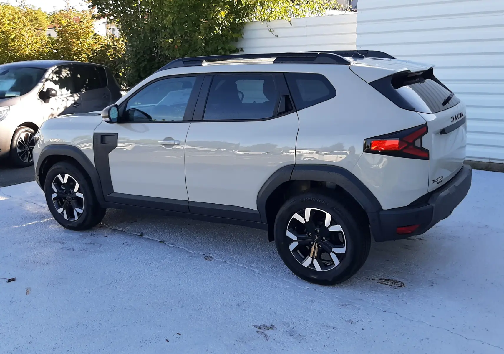 Dacia Duster 2025 couleur sandstone vue de profil côté gauche, avec jantes noires et détails noirs contrastants.