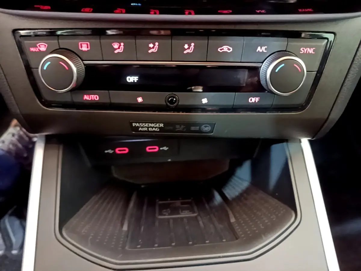 Vue rapprochée de la console centrale du SEAT Arona 2022, mettant en valeur la climatisation digitale et la zone de recharge sans fil.