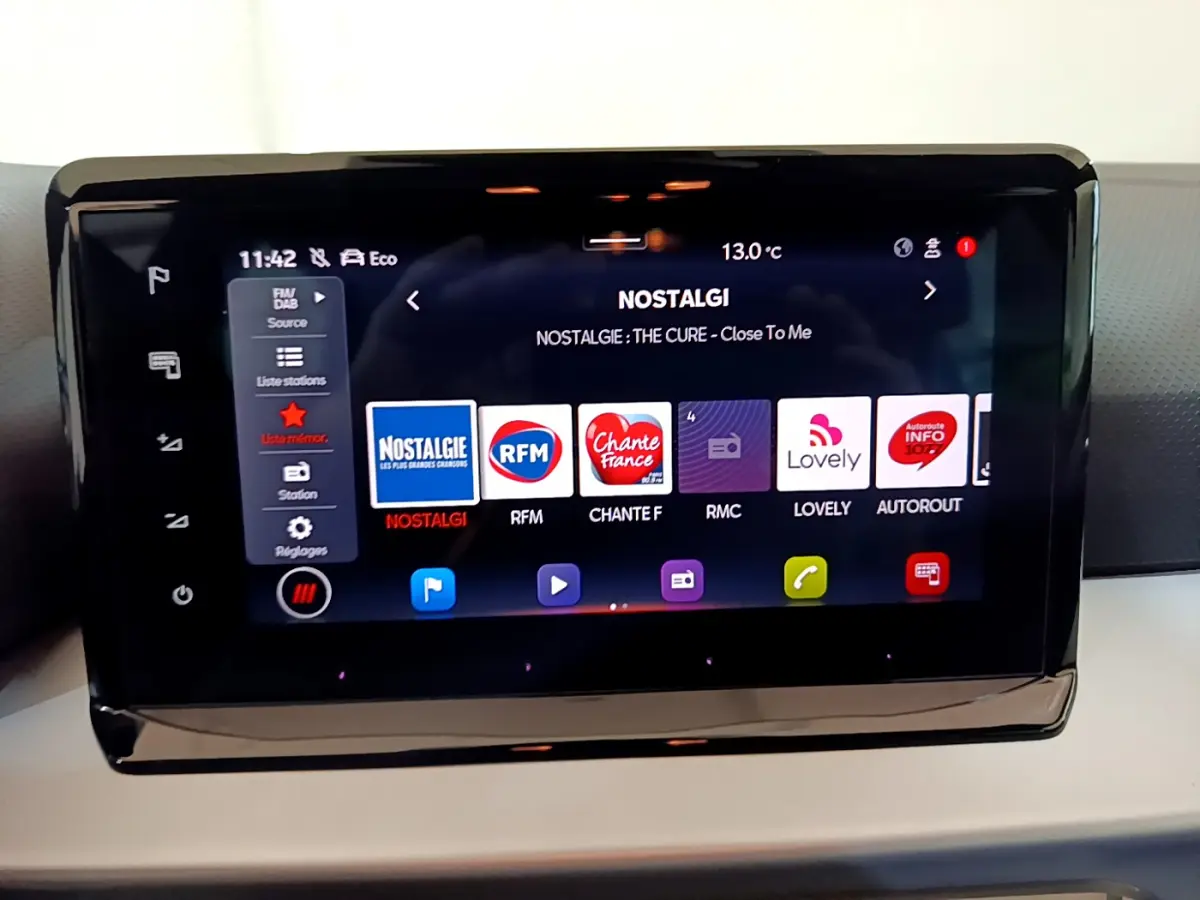 Écran tactile central du tableau de bord d'une SEAT Arona 2022 affichant les stations radio en mode nuit.