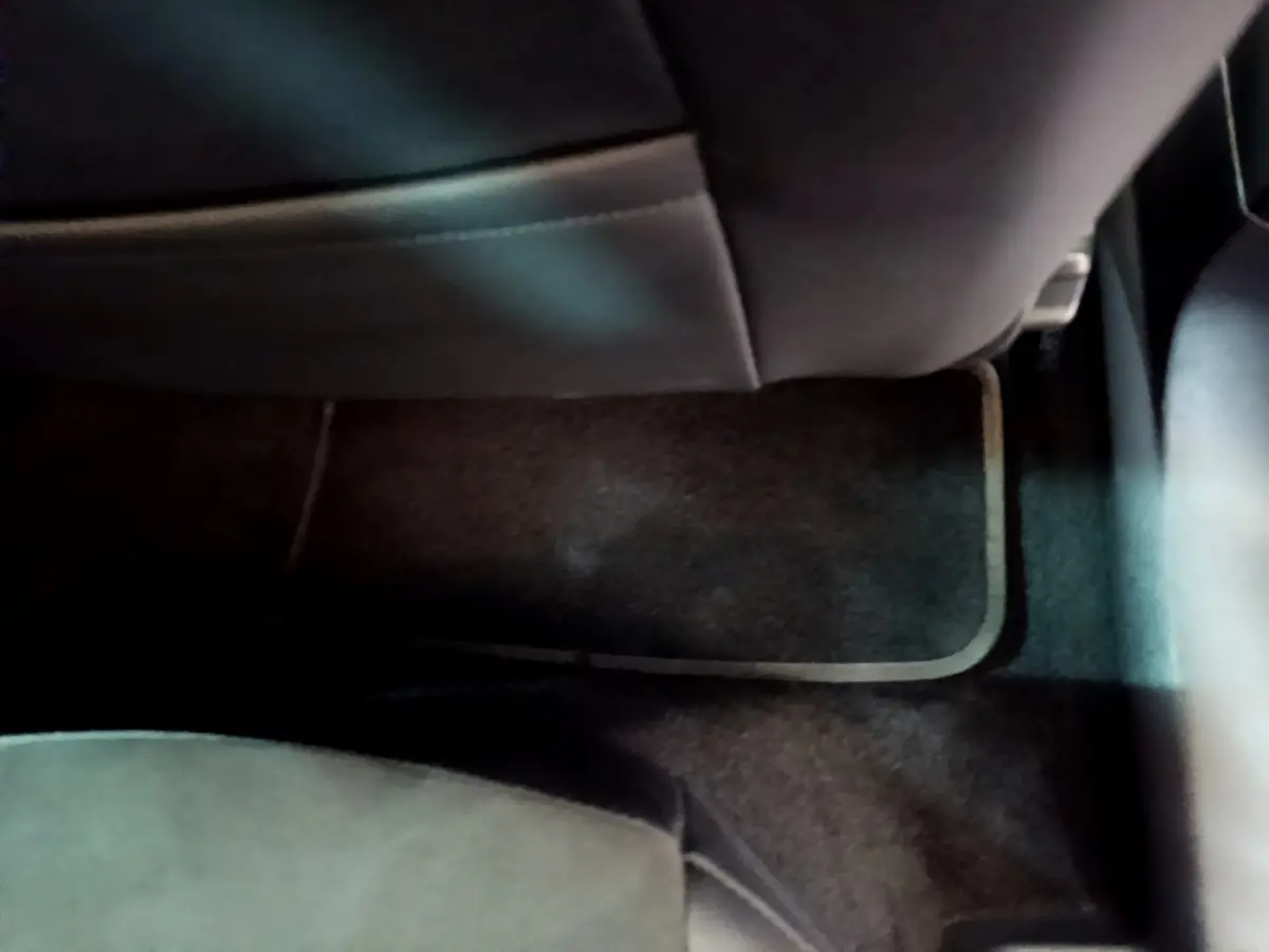 Plancher arrière avec tapis noir et siège en cuir sombre du SEAT Arona bleu 2022, version FR.