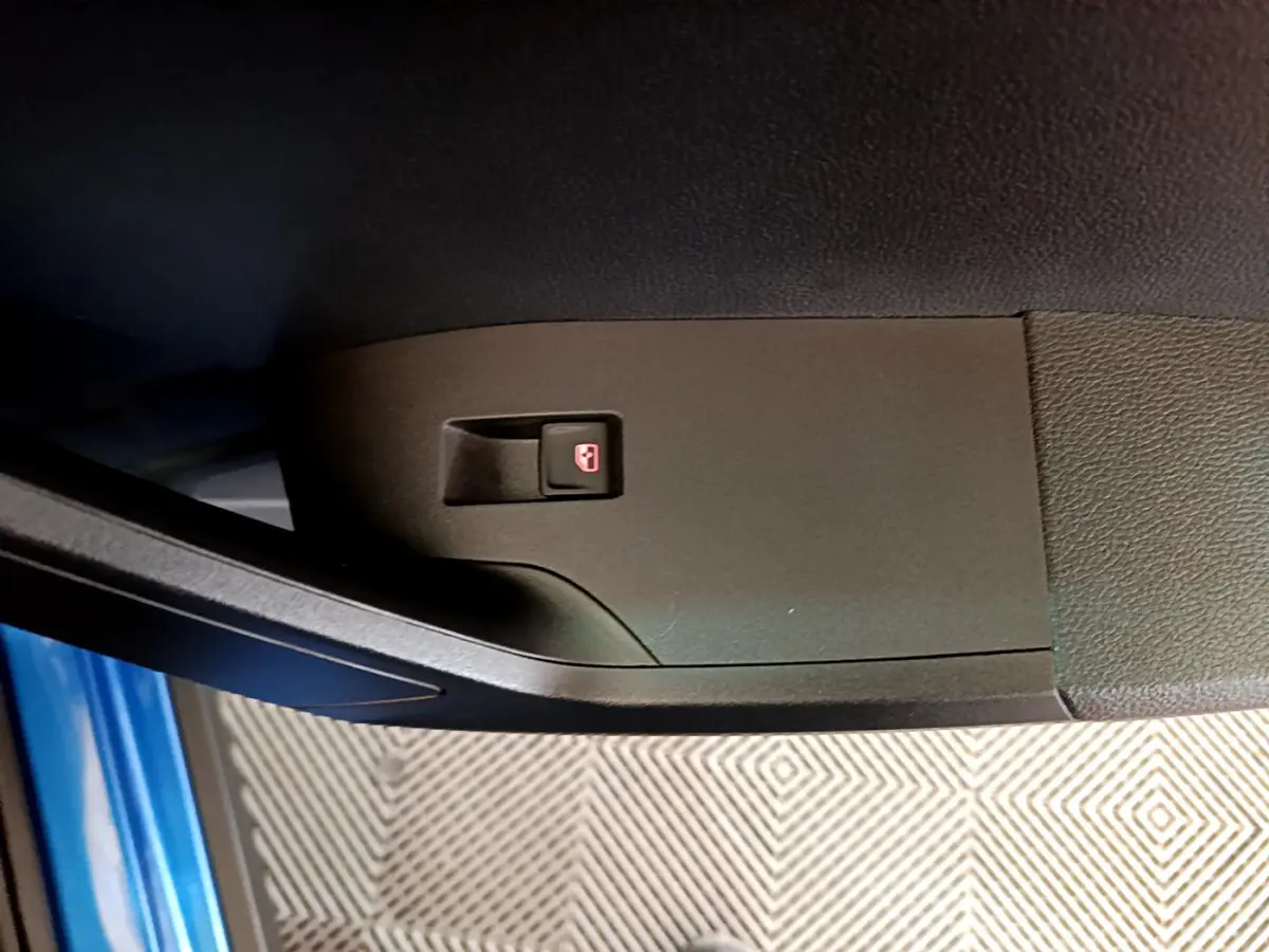 Bouton de verrouillage des portes sur la portière côté conducteur d'une SEAT Arona bleu 2022.