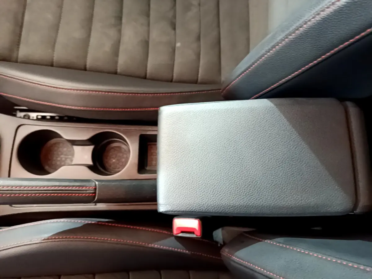 Gros plan sur la console centrale et les sièges noirs avec surpiqûres rouges du SEAT Arona 2022 finition FR.