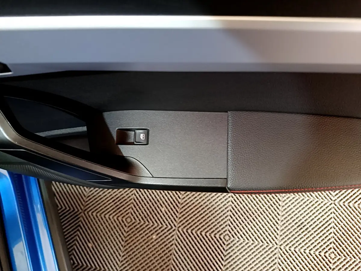 Détail de la porte côté gauche d'une SEAT Arona bleu 2022 avec bouton de verrouillage intégré.