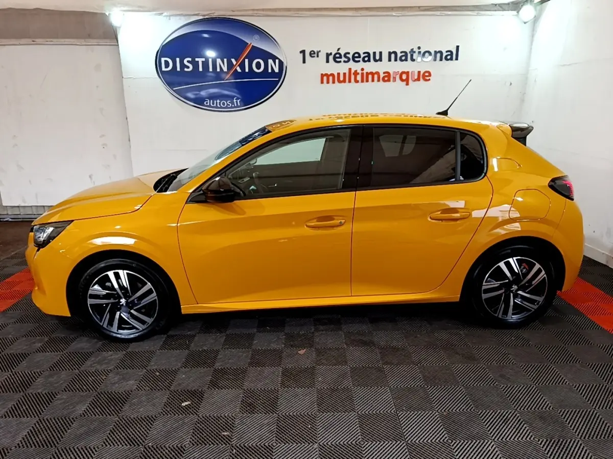 Peugeot 208 jaune vue de profil côté gauche, avec jantes alliage et vitres teintées dans un showroom.