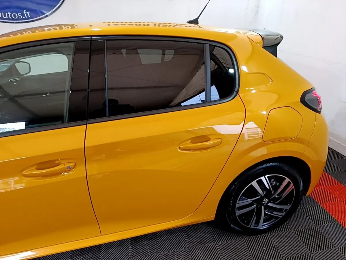 Vue latérale droite d'une Peugeot 208 jaune 2023 avec jantes alliage et vitres teintées.